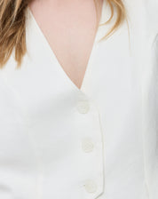 Vista traseira do colete branco cropped mostrando a fenda central na barra e o acabamento limpo