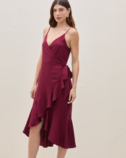 Close-up do decote em V transpassado, alças finas e detalhe da amarração lateral do vestido midi vinho em viscose.