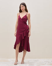 Vestido midi transpassado vinho em viscose com babado assimétrico e alças finas — vista frontal completa do look.