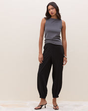 Calça Jogger Aladim preta - visão frontal com modelagem fluida, cintura alta e barras elásticas em viscose e lyocel