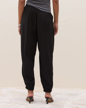 Calça Jogger Aladim preta - vista frontal alongada mostrando caimento largo e bolsos laterais discretos