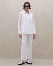 Detalhe da camisa off-white com mangas dobradas e passador, punho simples e barra arredondada - tecido liso 55% algodão