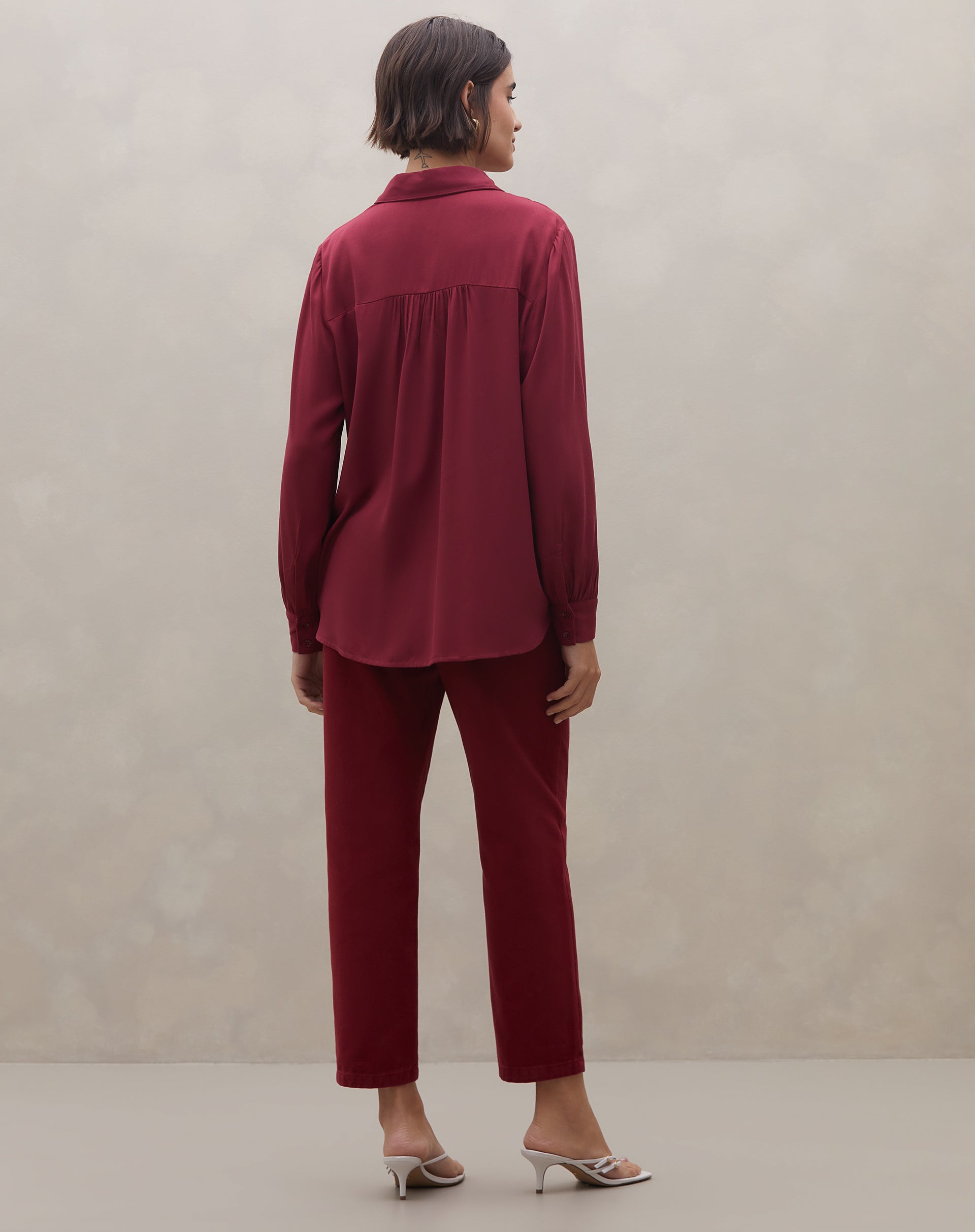 Close no ombro e decote da camisa vinho em viscose, realçando o corte do colarinho e a textura lisa